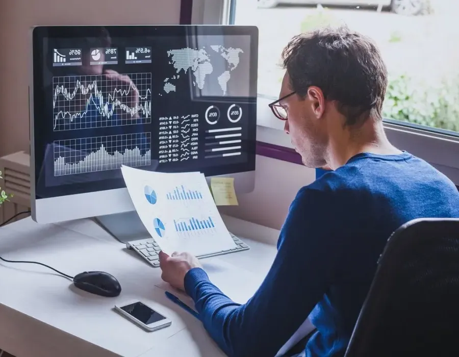 Data analyst seated at desk reviewing performance metrics